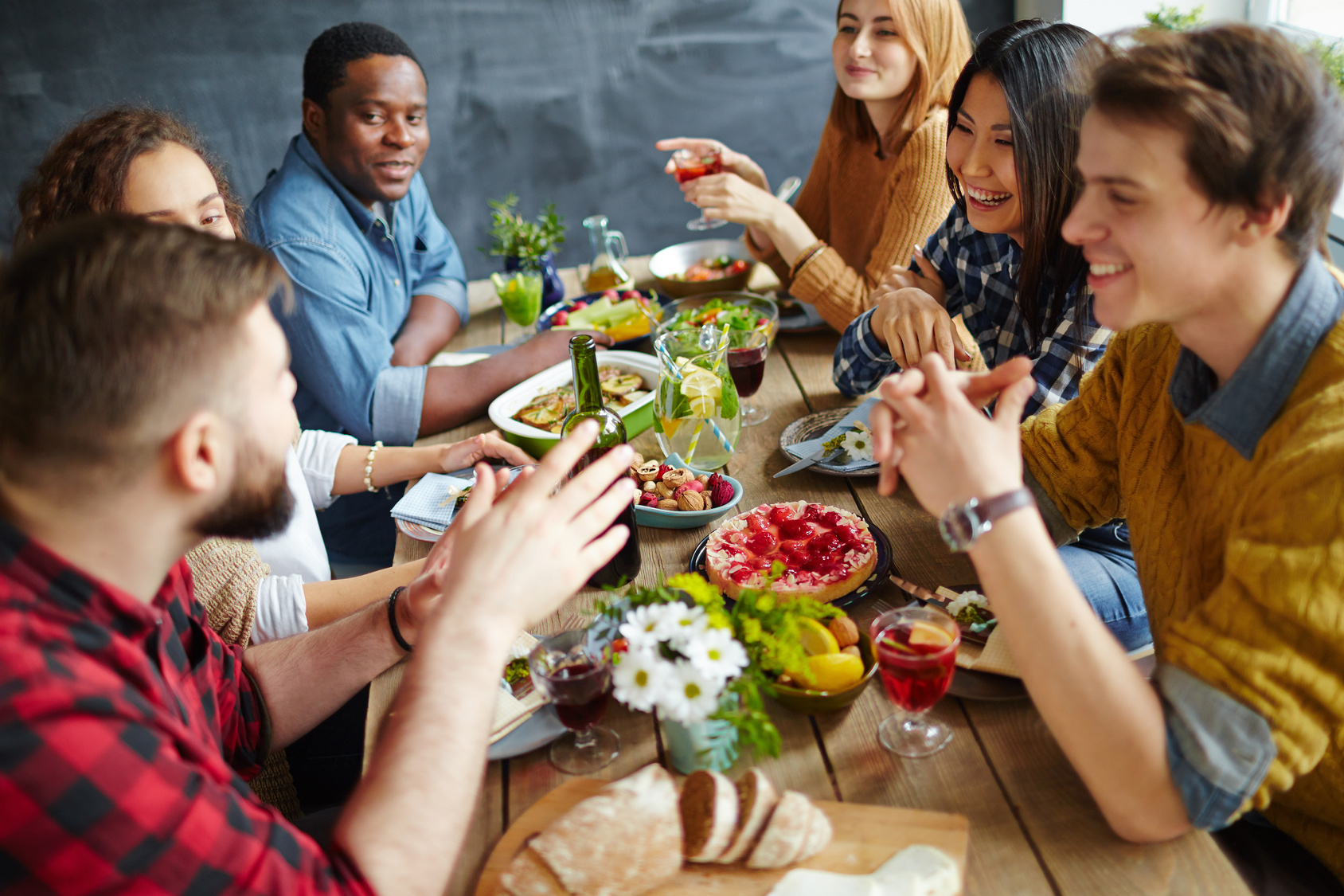 Groupe de personnes partageant un repas dans une ambiance joviale.