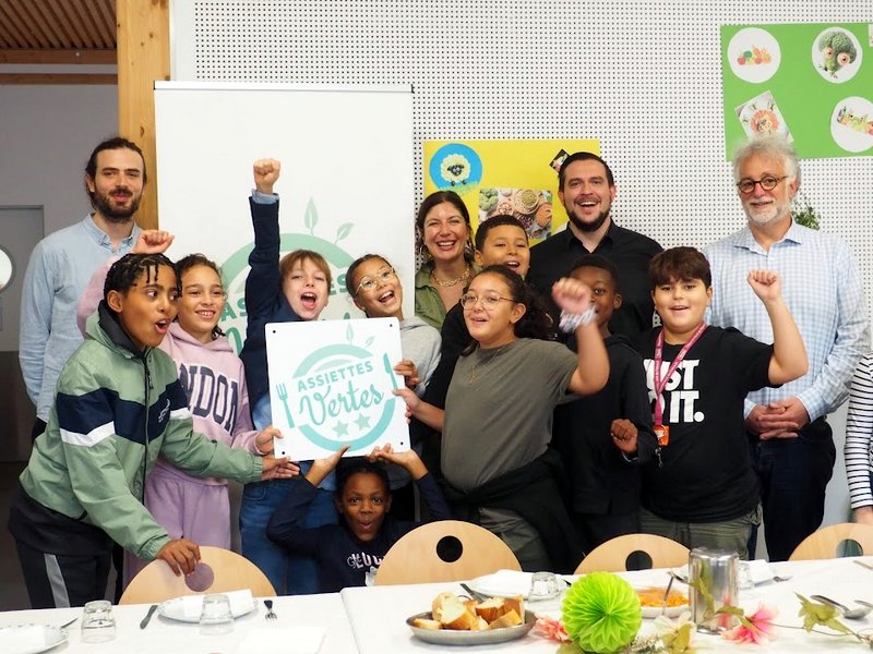 Des enfants tiennent une pancarte avec le label Assiettes Vertes